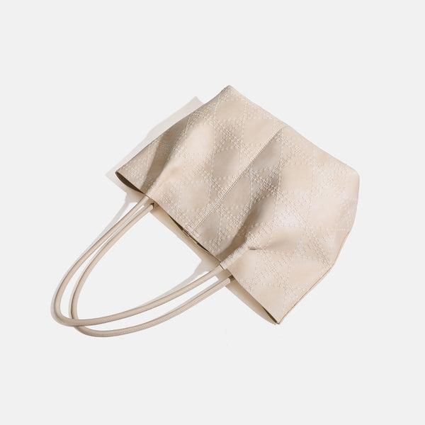 Large open-top tote bag with raised diamond-lattice stitching, long double shoulder handles, and gold-tone magnetic snap