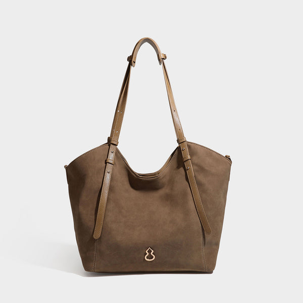 Oversized suede-finish tote shoulder bag in caramel brown with slim leather-look straps and gold-tone logo hardware, detail