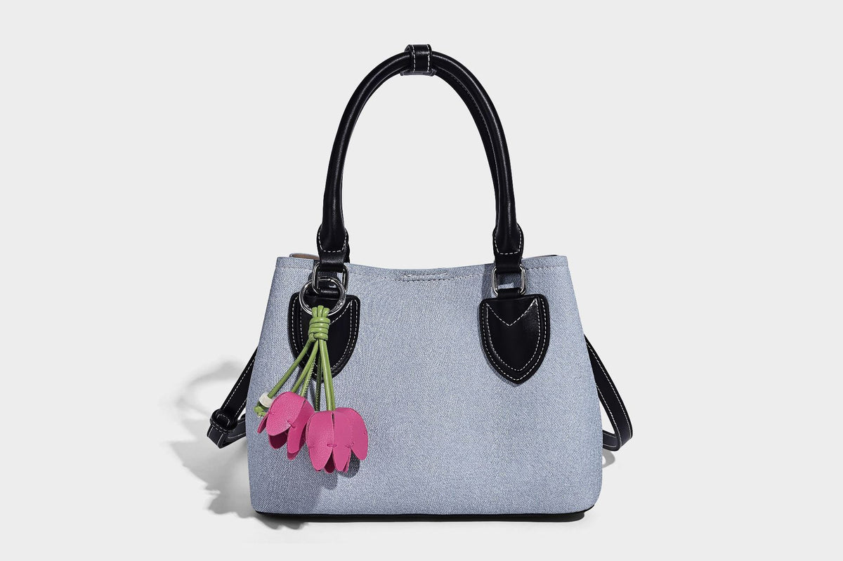 Structured light-blue denim-look tote bag with black leather-look handles, white contrast stitching, silver-tone hardware