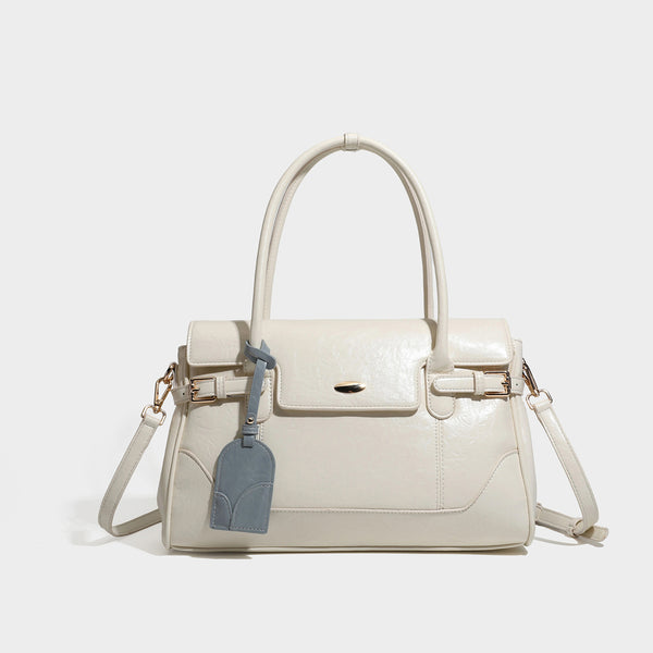 Structured glossy leather-look satchel bag with flap closure, gold-tone buckle accents, double top handles, detachable