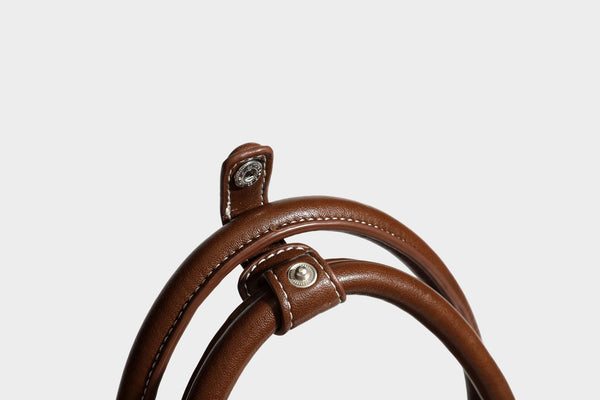 Patchwork suede-look barrel shoulder bag in brown, rust, tan, beige, and gray panels with double leather-look straps and