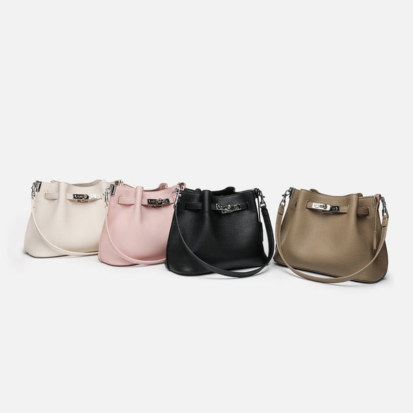 Soft-structured pebbled leather-look bucket bag with silver turn-lock front clasp and adjustable crossbody strap, detail view