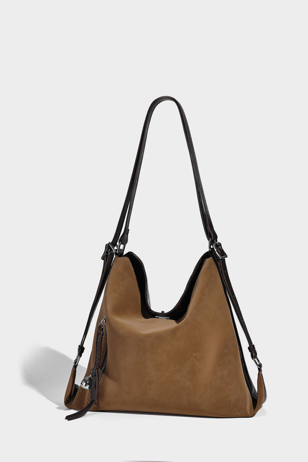 Slouchy hobo tote bag with matte leather-look finish, triangular silhouette, front zip pocket, and adjustable shoulder strap