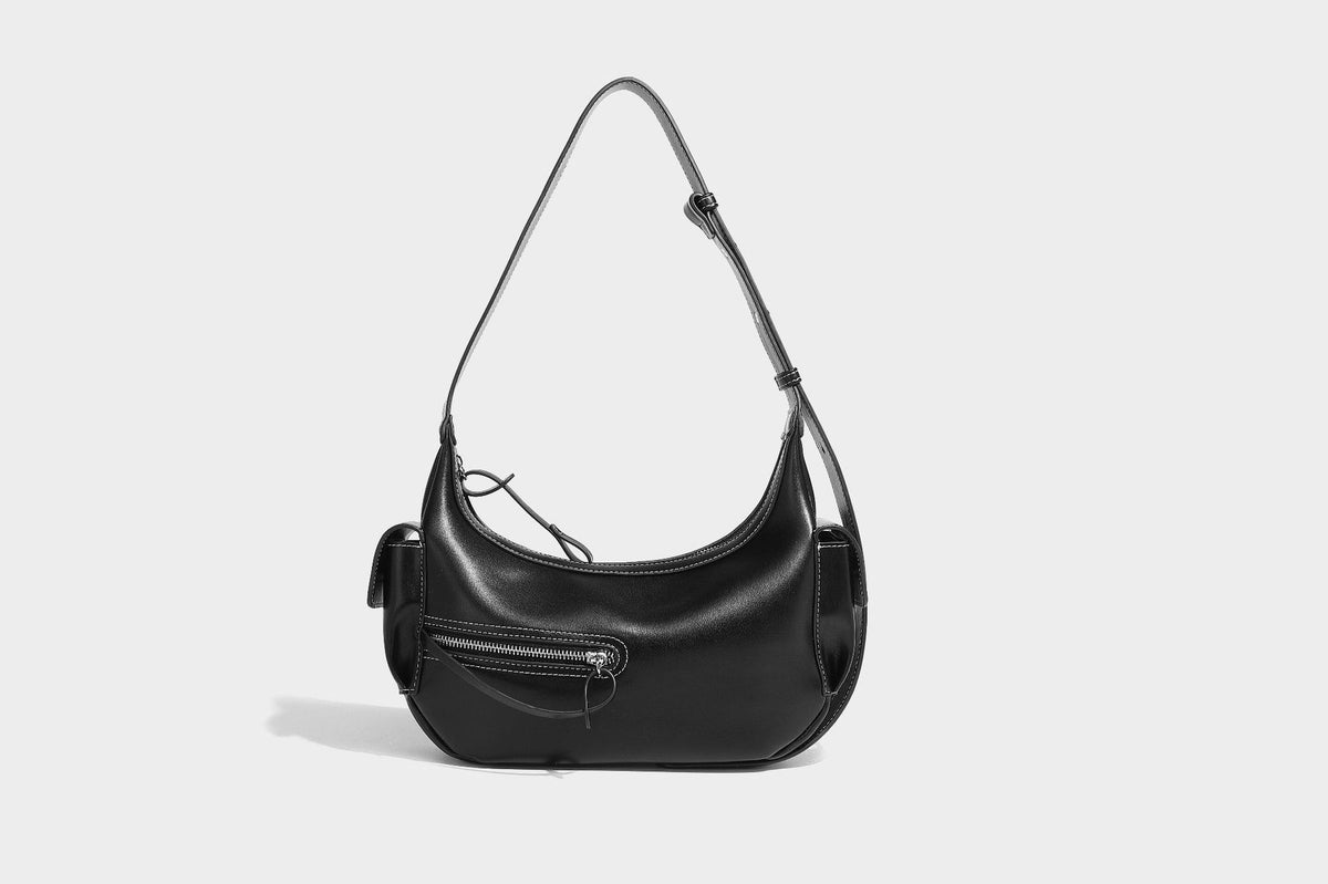 Smooth leather-look crescent shoulder bag with front zip pocket, side flap pockets, adjustable strap, and silver-tone, detail