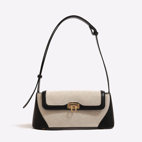 Structured trapezoid flap shoulder bag with canvas-textured body, smooth contrast trim, and gold-tone turn-lock clasp, front