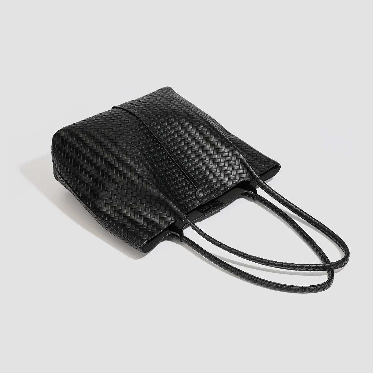 Large black basket-weave leather-look tote bag with long braided shoulder straps and matching woven zip pouch, detail view 4