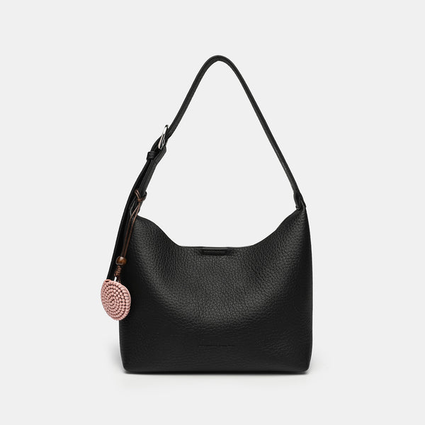 Slouchy hobo shoulder bag in pale yellow pebbled texture with woven charm, adjustable strap, matching zip pouch, and, detail