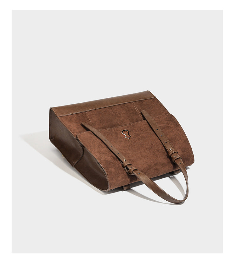 Structured suede-look convertible backpack handbag with flap closure and gold-tone emblem hardware in chocolate brown, detail