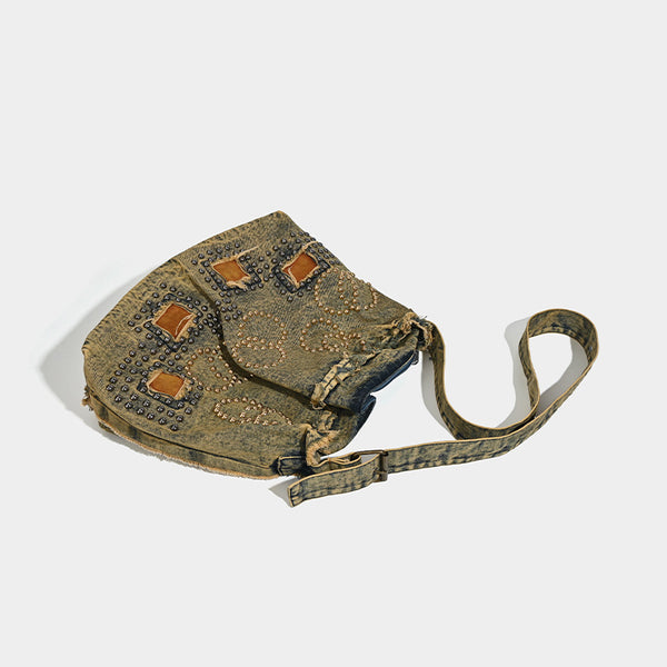 Large distressed denim hobo shoulder bag with mixed-metal rivet detailing and tan leather-look corner trim, detail view 3