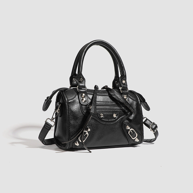 Mini-Henkeltasche mit formstabiler Silhouette, silberfarbenen Nietenbeschlägen, Reißverschlussfach vorne, zwei Tragegriffen und abnehmbarem Schulterriemen