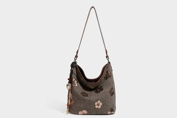 Lässig fallende Hobo-Schultertasche aus anthrazitfarbenem Webstoff mit floraler Stickerei aus silberfarbenen Pailletten, schwarzem Besatz in Lederoptik und langem