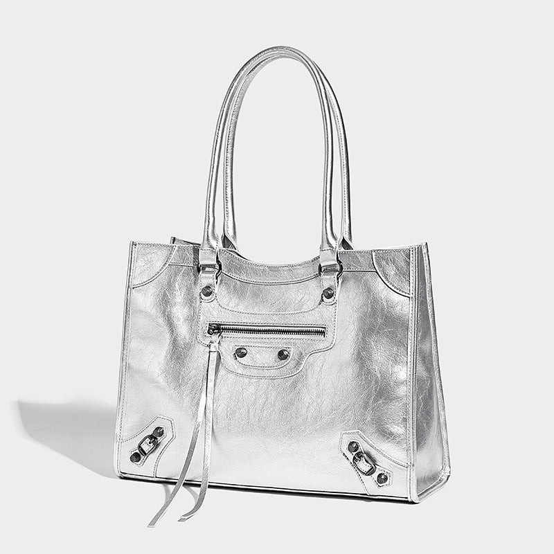 Large structured leather-look tote bag with front zip pocket, moto hardware accents, and long double shoulder straps, detail