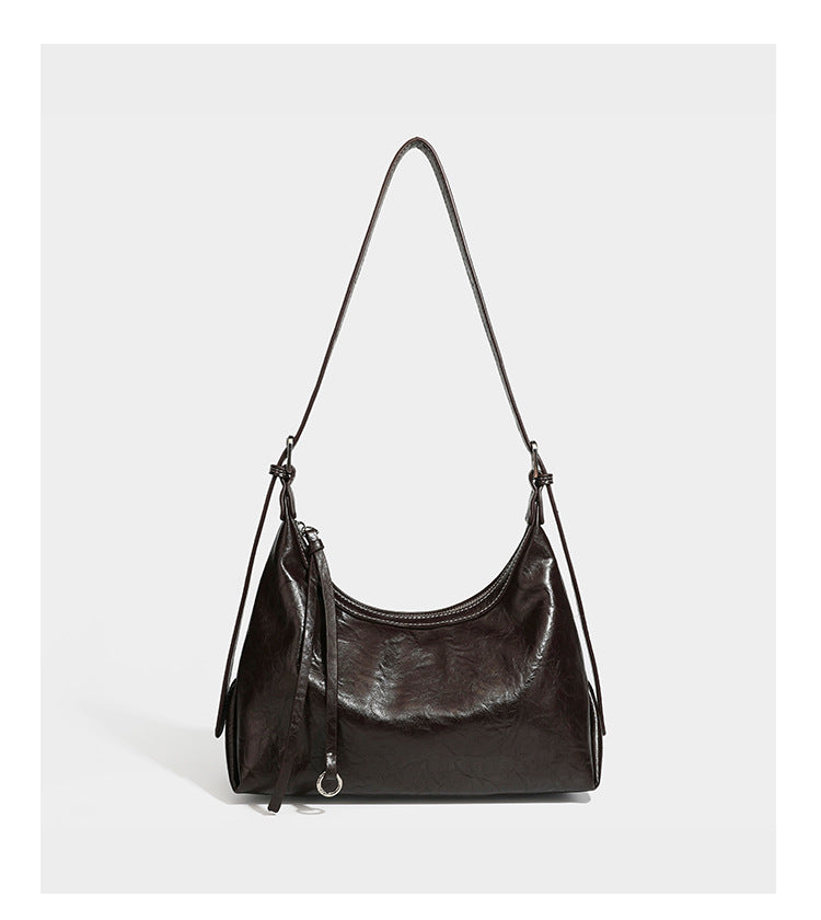 Slouchy hobo shoulder bag in glossy crinkled leather-look finish with zip-top closure and silver-tone ring hardware, detail