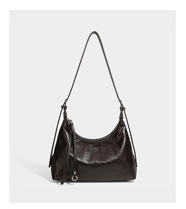 Slouchy hobo shoulder bag in glossy crinkled leather-look finish with zip-top closure and silver-tone ring hardware, detail