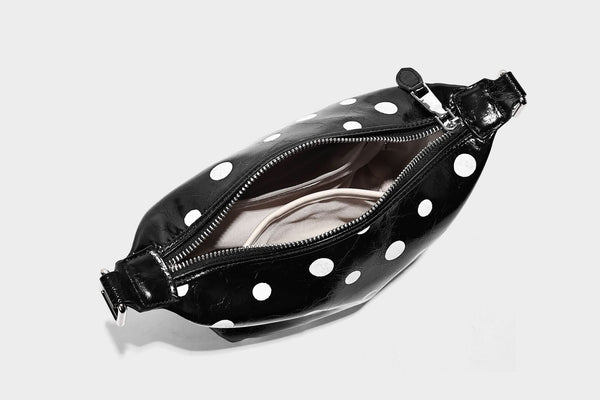 Kompakte glänzende Hobo-Schultertasche in Schwarz mit weißen Punkten, Reißverschluss, Beschlägen in Gunmetal und befestigtem Überschlag vorne