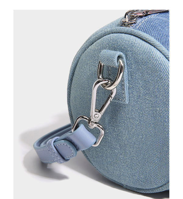Mini barrel handbag in light and dark denim patchwork with frayed seam trim, dual top handles, top zip closure, and, detail
