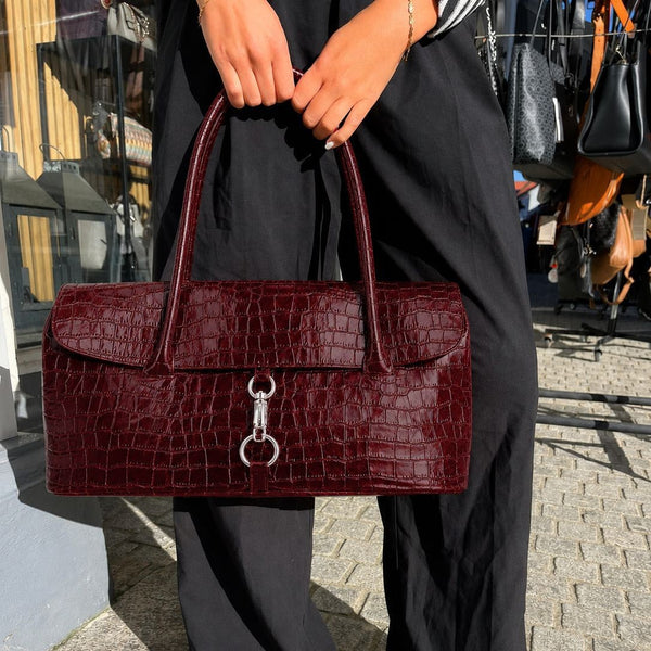 Glänzende, strukturierte Schultertasche mit Krokoprägung, Klappe, silberfarbenen Ring- und Knebelverschlüssen sowie zwei Henkeln an der Oberseite, Detailansicht 2