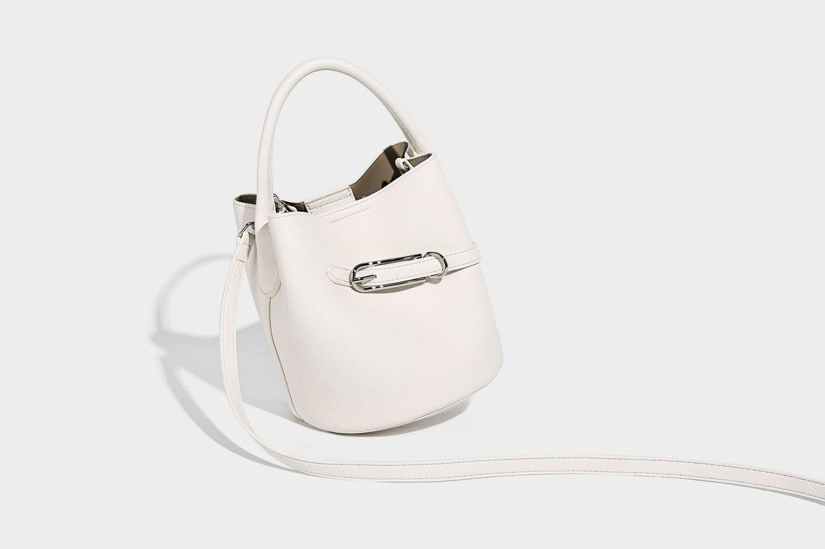 Mini pebbled leather-look bucket bag with front buckle strap, silver-tone hardware, top handle, and detachable shoulder