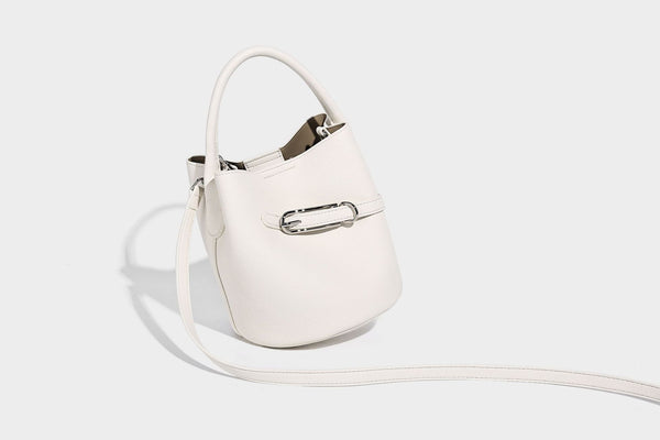 Mini pebbled leather-look bucket bag with front buckle strap, silver-tone hardware, top handle, and detachable shoulder