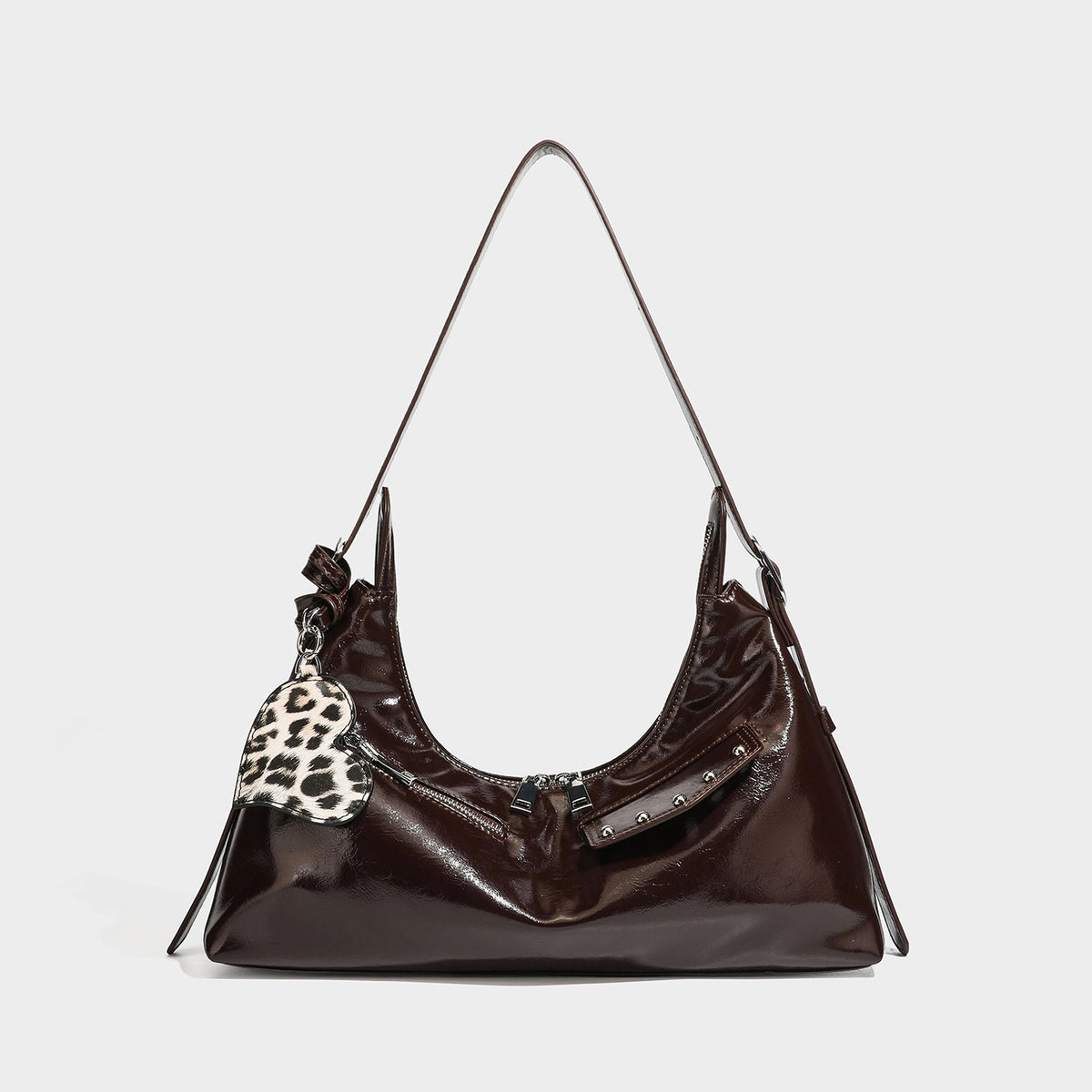 Glossy dark brown hobo shoulder bag with slim strap, front zip pocket, stud detail, and detachable leopard-print heart charm
