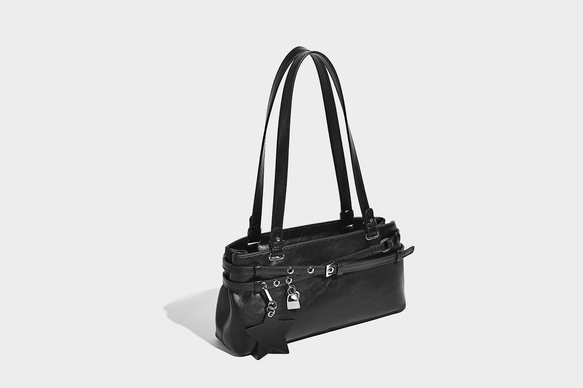 Structured glossy leather-look shoulder bag with wraparound belt straps, silver-tone hardware, and dangling star charm
