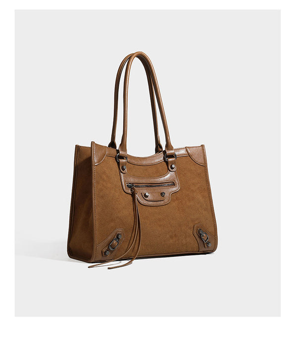 Large structured tote bag with matte suede-like body, smooth leather-look trim, front zip pocket, stud hardware, and