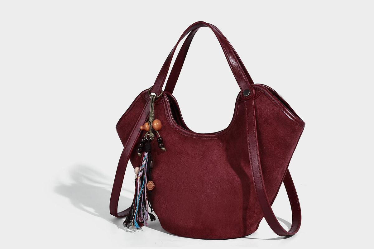 Dunkelbraune matte Hobo-Schultertasche in Velourslederoptik mit geschwungener, oben offener Silhouette, zwei Schulterriemen und abnehmbarem