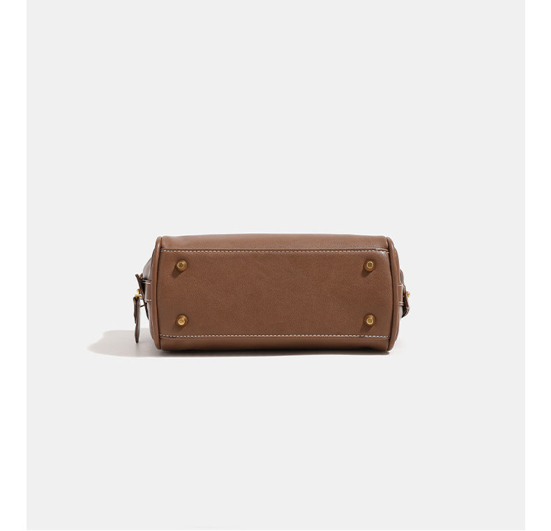 Compact structured satchel bag with dual top handles, gold-tone O-ring hardware, contrast topstitching, and detachable