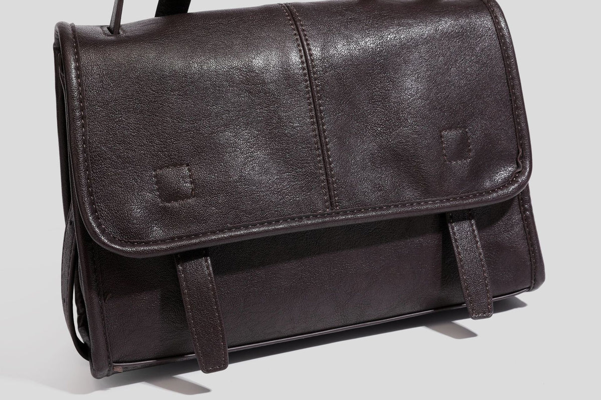 Strukturierte Satchel-Tasche mit Überschlag aus dunkelbrauner, glänzender Lederoptik, kurzem Tragegriff und langem, verstellbarem Schulterriemen