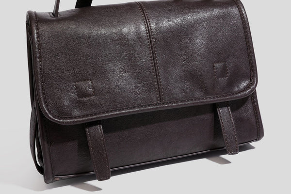 Strukturierte Satchel-Tasche mit Überschlag aus dunkelbrauner, glänzender Lederoptik, kurzem Tragegriff und langem, verstellbarem Schulterriemen