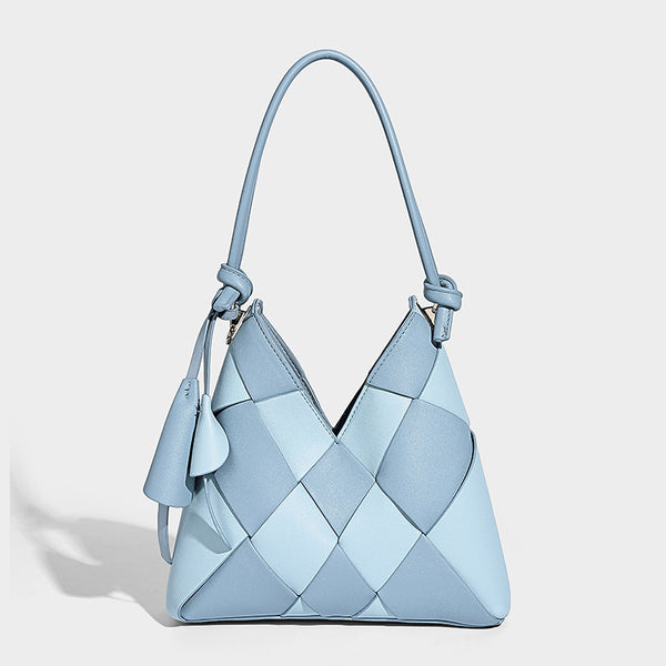 Compact bucket shoulder bag with black-and-white diamond patchwork panels, knotted top handle, gold-tone hardware, and
