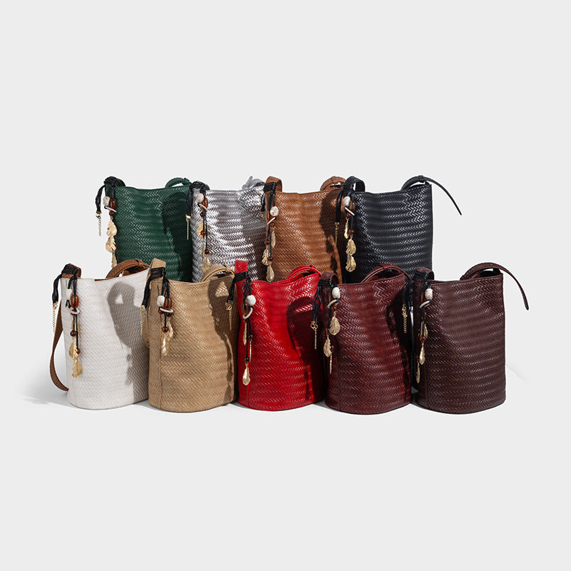 Chevron woven leather-look bucket bag with adjustable shoulder strap and gold charm pendant, detail view 2