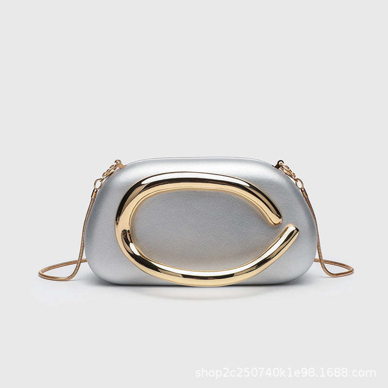 Kleine rechteckige Crossbody-Clutch mit abgerundeten Ecken, oversized poliertem C-förmigem Goldgriff und schmalem Goldkettenriemen, Detailansicht