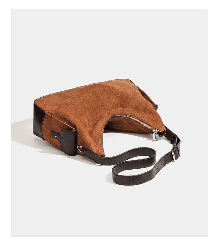 Cognac brown suede-look slouchy shoulder bag with dark brown leather-look trim, top zip closure, exterior side pocket, and