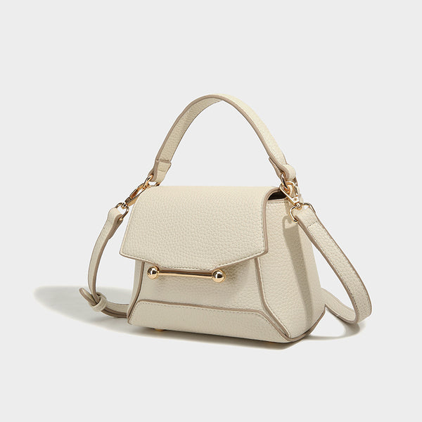 Small structured pebbled flap mini satchel with gold-tone bar hardware, short top handle, and detachable crossbody strap