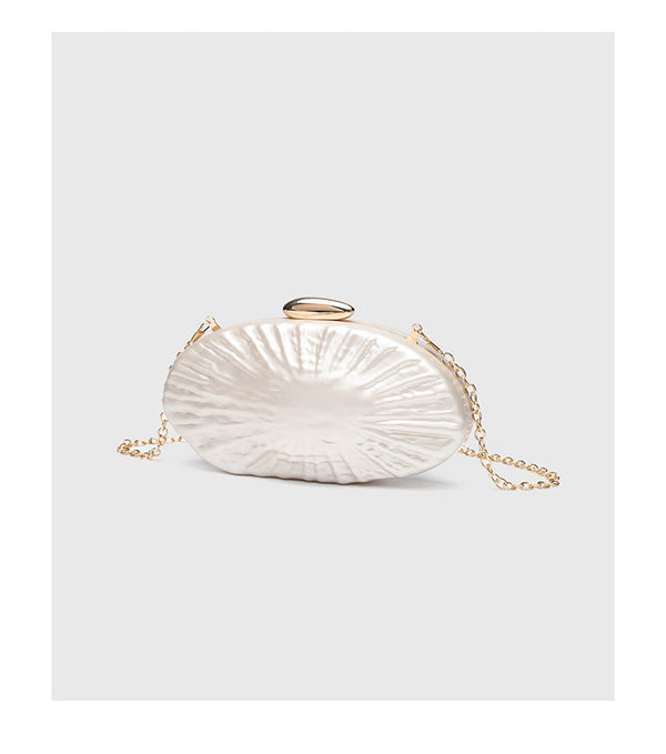 Oval pearl-finish shell clutch bag with gold-tone clasp and removable gold link chain strap, detail view 10