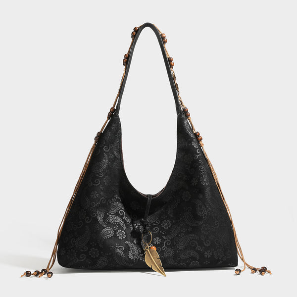 Slouchy boho hobo shoulder bag in embossed brown suede-look finish with beaded strap, cord tassels, and brass-tone leaf