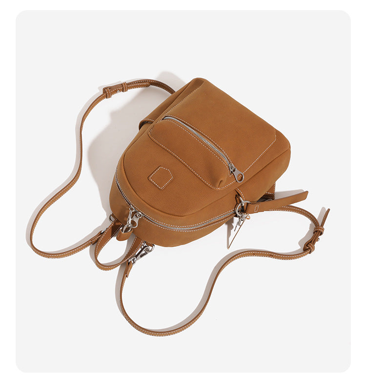 Mini-Rucksackhandtasche mit abgerundeter Form und genarbter Oberfläche, silberfarbenen Beschlägen, Reißverschlussfach vorne und verstellbaren Rucksackriemen
