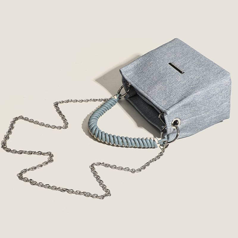 Small structured trapezoid mini bag with coiled rope top handle and silver-tone chain strap in textured fabric, detail view 4