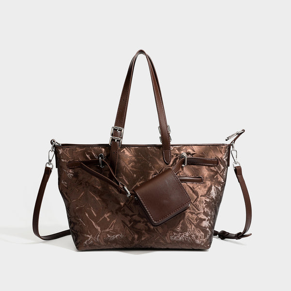 Glossy crinkled metallic-finish tote bag in brown with smooth leather-look top handles, silver-tone hardware, and attached