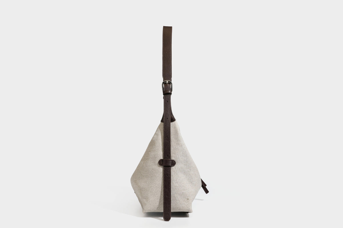 Lässige Hobo-Schultertasche aus haferfarbenem Canvas mit dunkelbraunen Besätzen in Lederoptik, silberfarbenem Reißverschluss und langem, verstellbarem