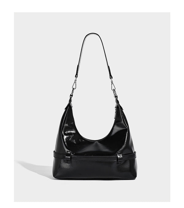 Glossy black slouchy hobo shoulder bag with silver-tone hardware, belt-style grommet strap at base, and long adjustable