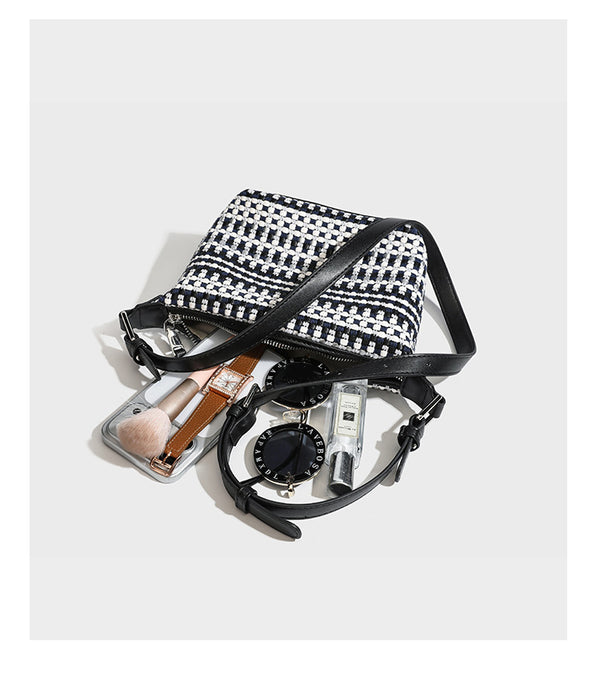 Small crescent shoulder bag in black-and-white woven textile with smooth black leather-look trim, zip-top closure, knotted