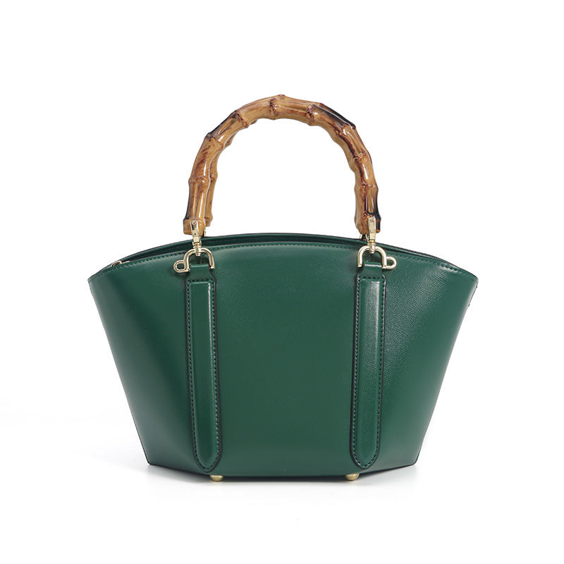 Structured trapezoid handbag with segmented bamboo top handle, smooth leather-look finish, gold-tone hardware, and vertical