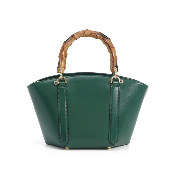 Structured trapezoid handbag with segmented bamboo top handle, smooth leather-look finish, gold-tone hardware, and vertical
