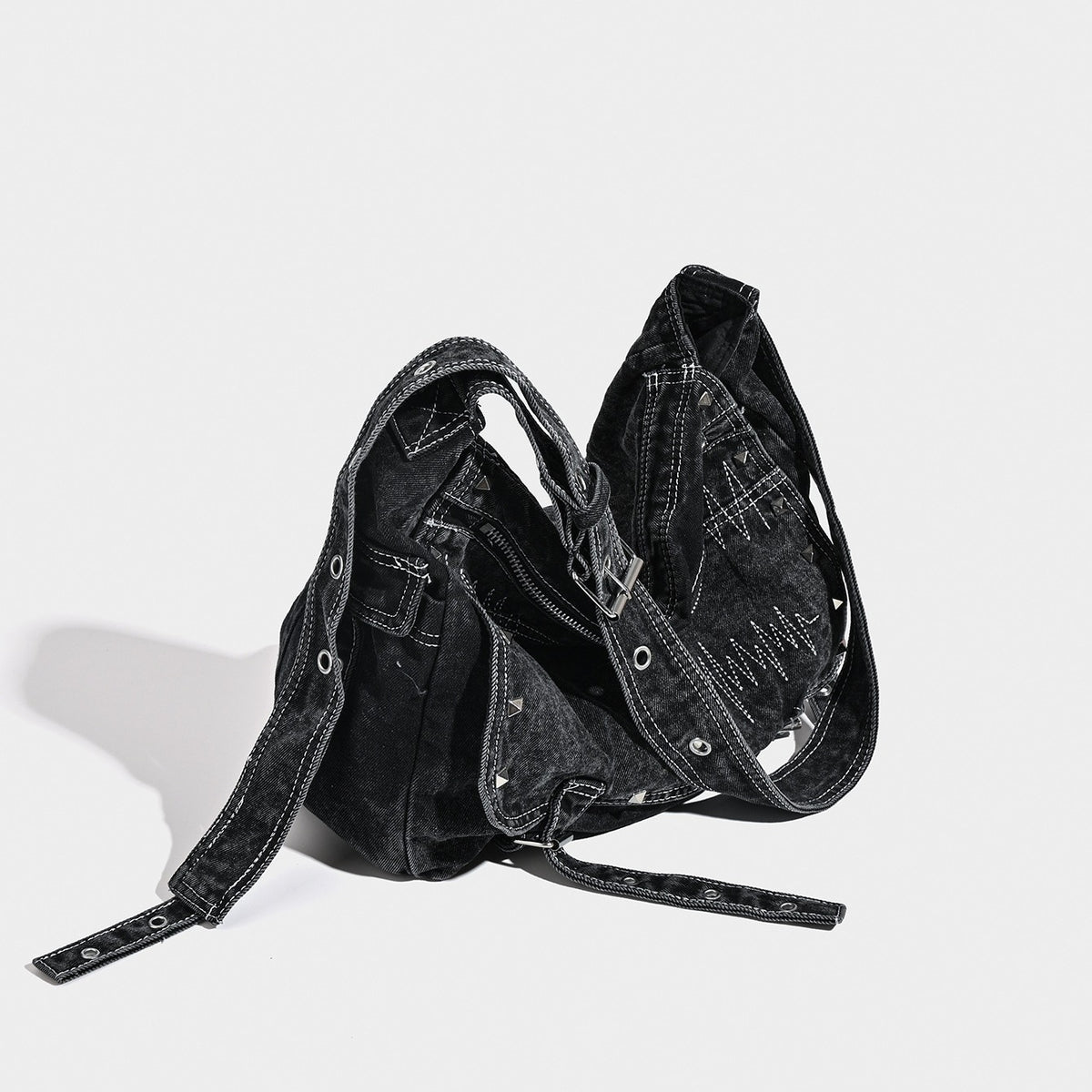 Large washed black denim hobo shoulder bag with silver rivet accents and adjustable crossbody strap, detail view 2