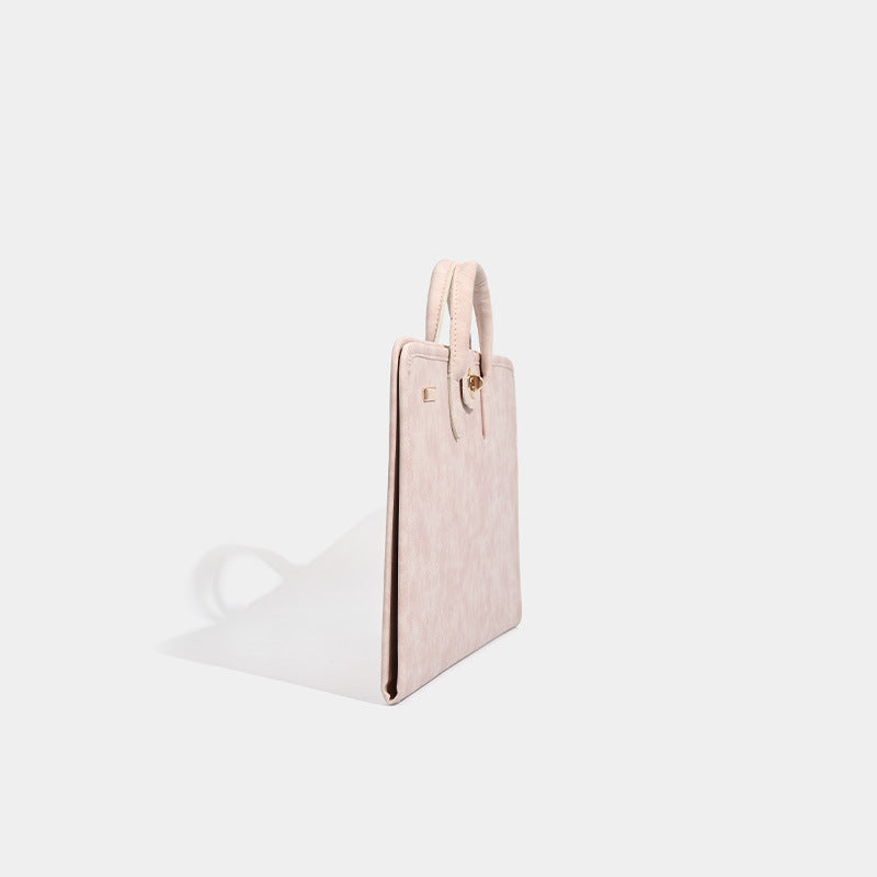 Blush pink structured flat tote bag with matte textured finish, dual top handles, and gold-tone twist clasp, detail view 2