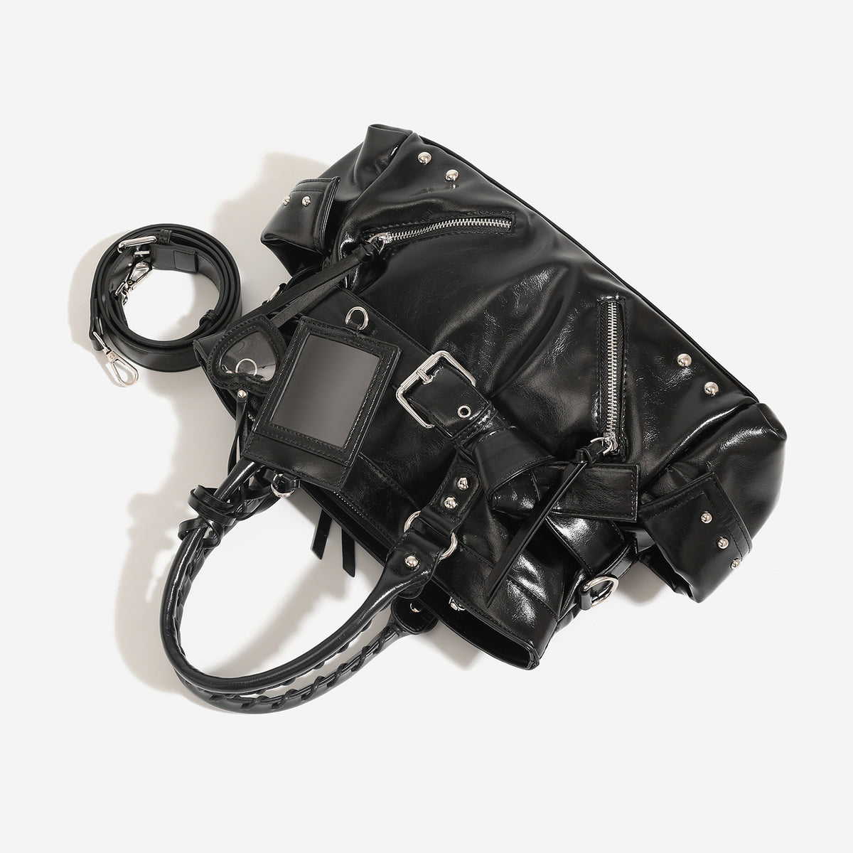 Black glossy leather-look structured tote bag with silver studs, buckle strap, exterior zip pockets, braided top handles