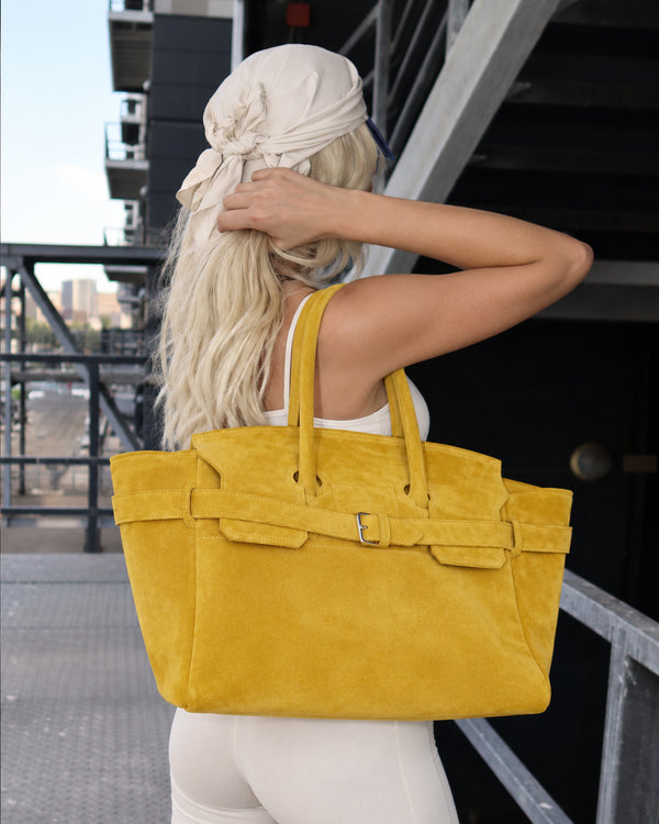 Große formstabile trapezförmige Tote-Bag mit matter, velourslederähnlicher Oberfläche, zwei Henkeln und Gürtelschnallen-Detail am Riemen, Detail