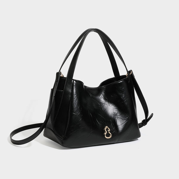 Black glossy crinkled leather-look convertible shoulder tote bag with gold gourd-shaped emblem hardware and detachable